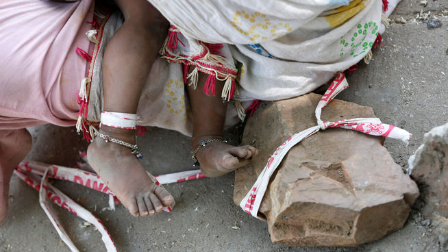 Niña india atada a una piedra