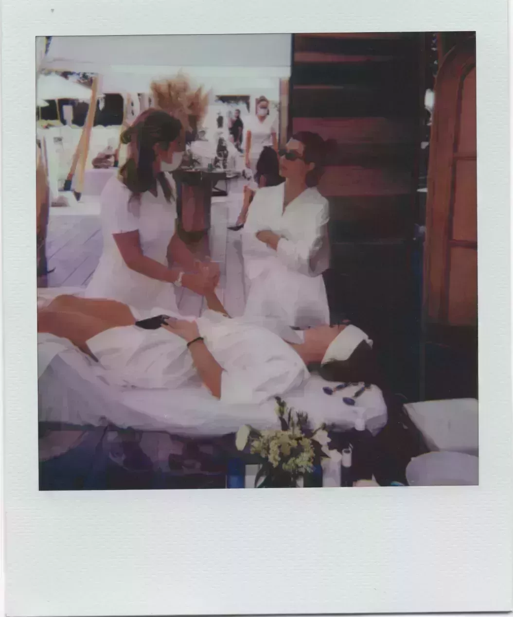 kourtney kardashian in white robe at poolside poosh event talking to person getting massage