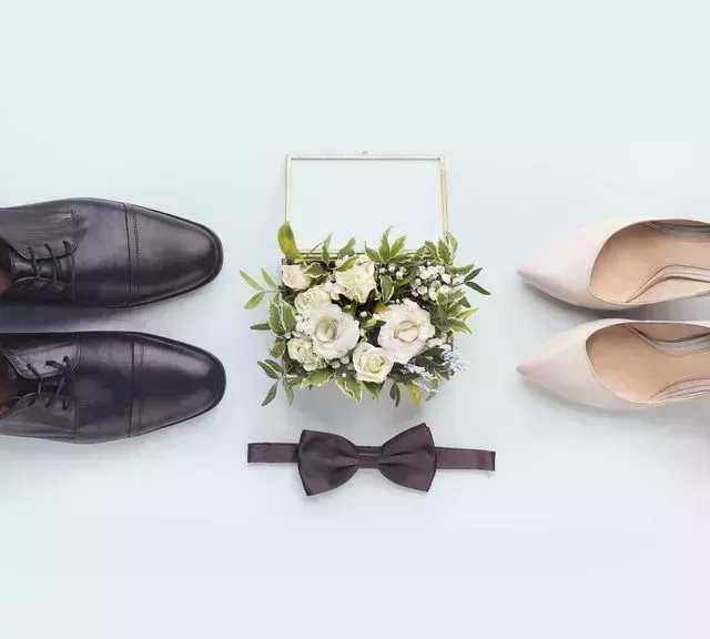 bride and groom accessories wedding shoes, bow tie and bouquet on white background, panorama in a story about how men have to get involved in wedding planning