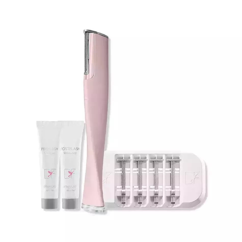 Dermaflash Luxe Sonic Dermaplaning & Peach Fuzz Removal pink dermaplaning device, spare razors, and two white tubes of gel on white background