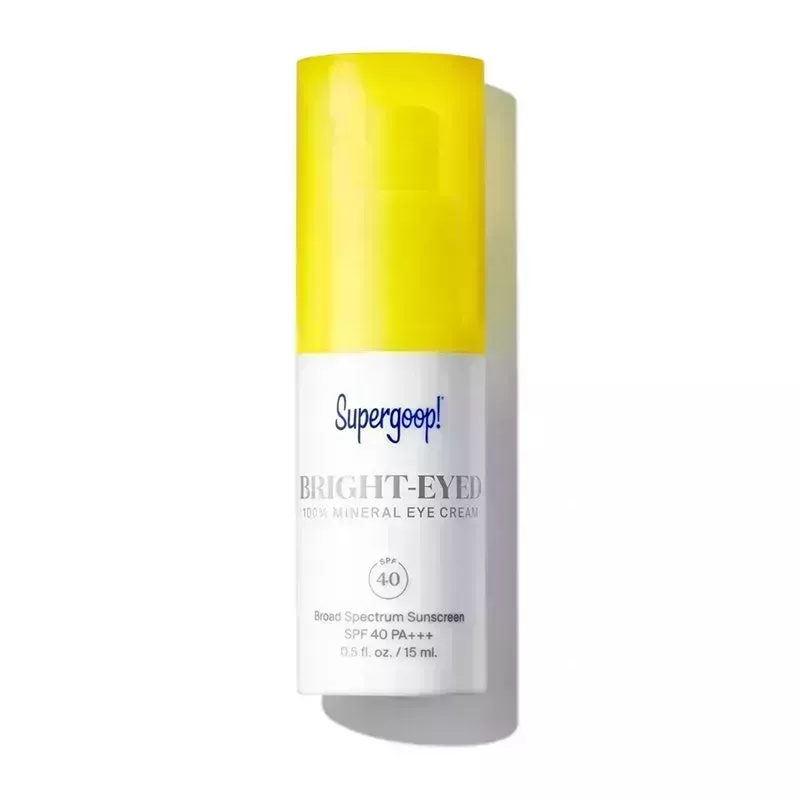 A white bottle with yellow cap of the Supergoop Bright-Eyed 100% Mineral Eye Cream SPF 40 on a white background