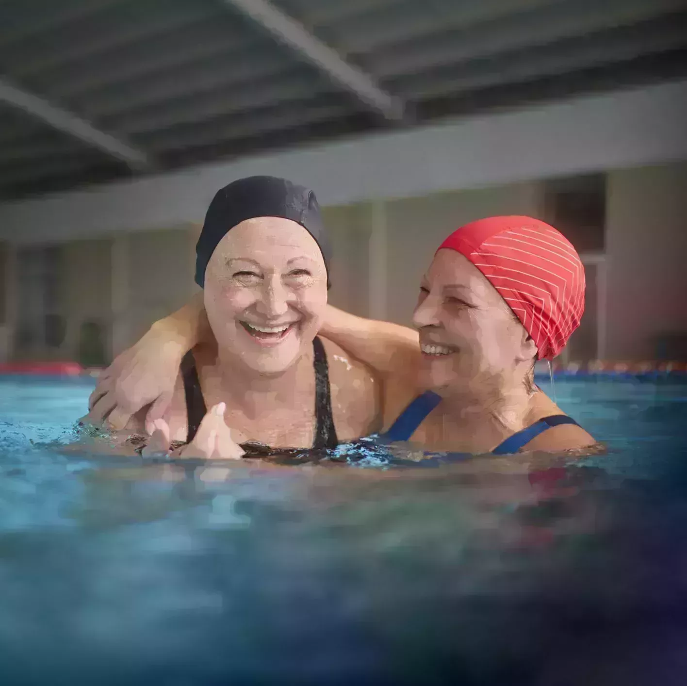 two senior women embracing together in swimming indoor pool