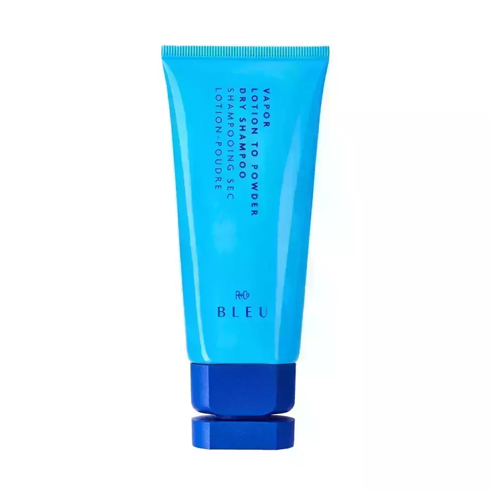 R+Co Vapor Lotion To Powder Dry Shampoo bright blue tube with darker blue cap on white background