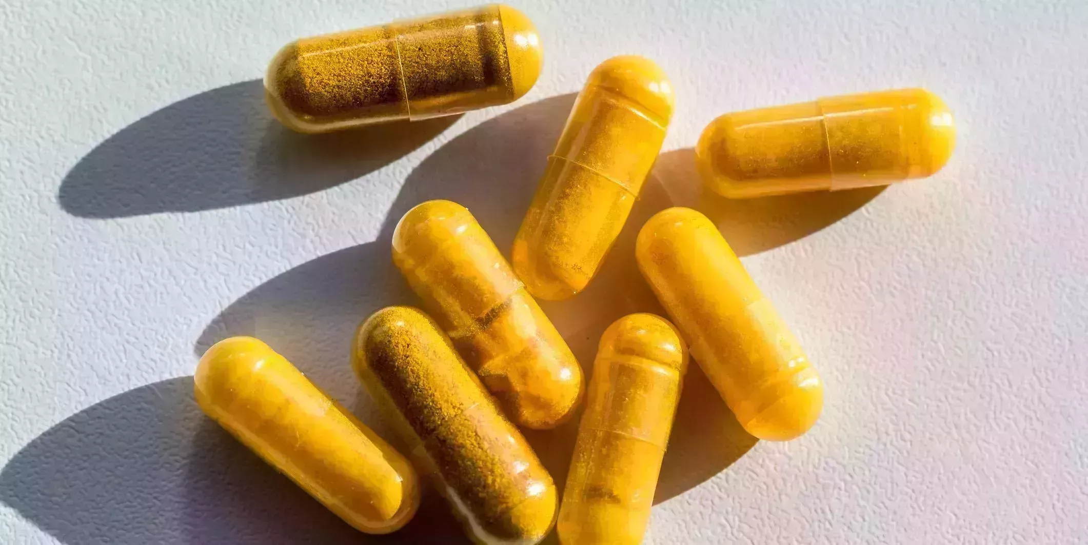 close up of turmeric capsules on table