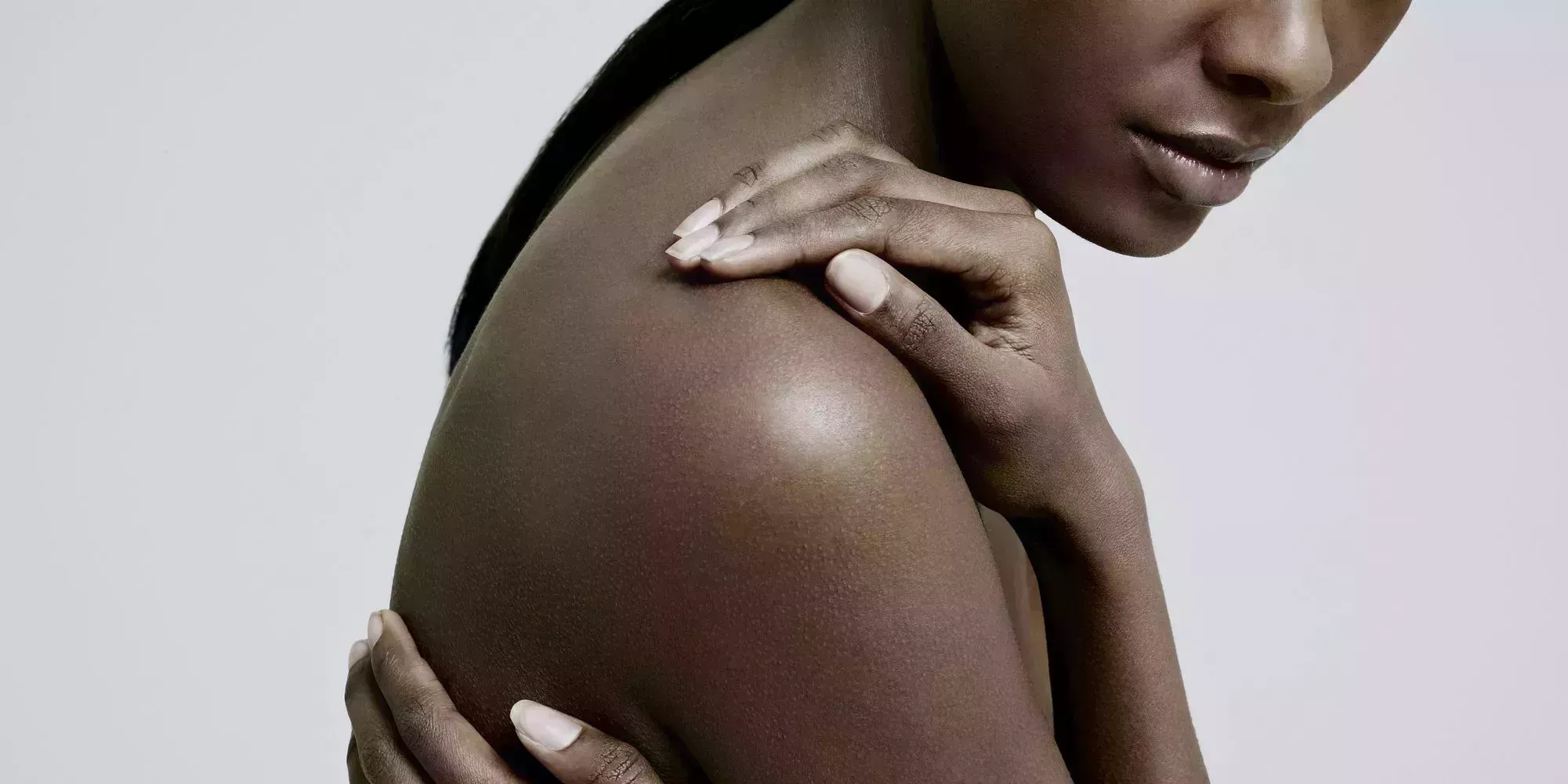 black female with hands on nude shoulder