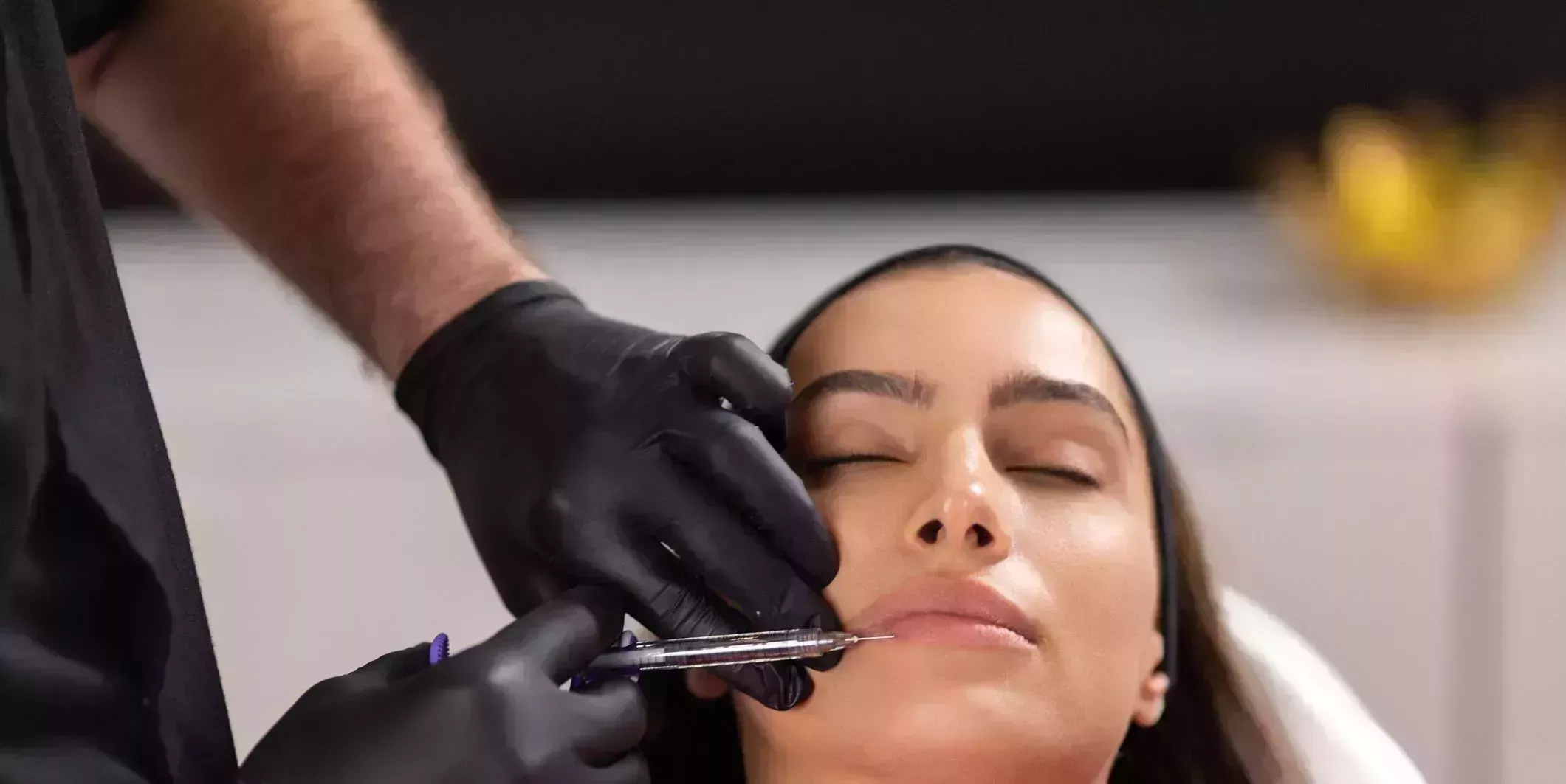 portrait of young woman receiving beauty treatment with botox filler