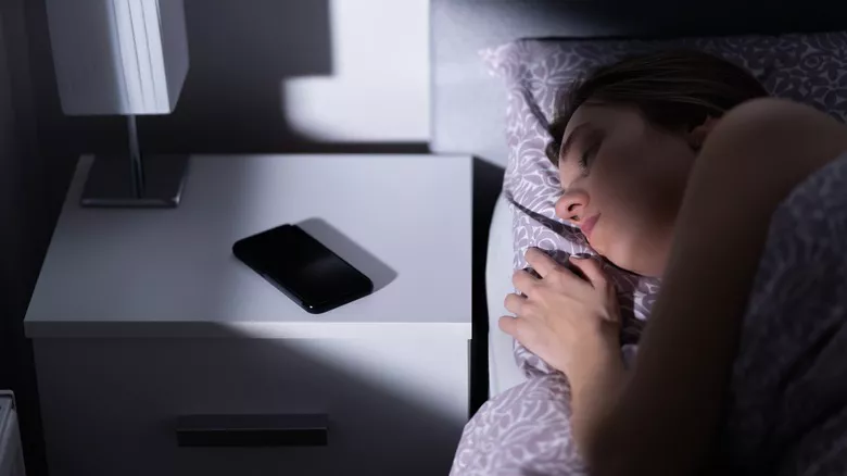 Mujer durmiendo al lado del teléfono