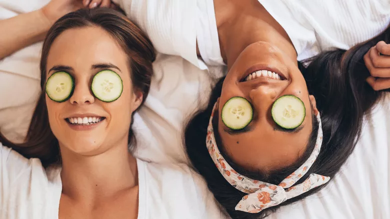 mujeres sonriendo con pepinos en los ojos