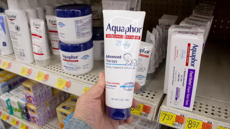 persona sosteniendo un tubo de Aquaphor