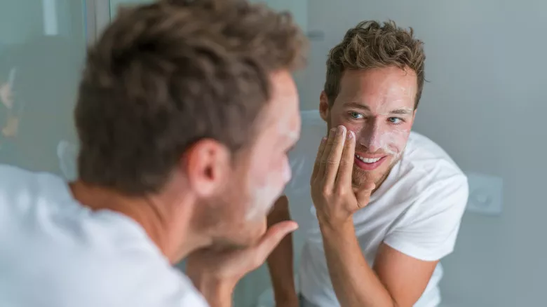 Hombre exfoliando la cara