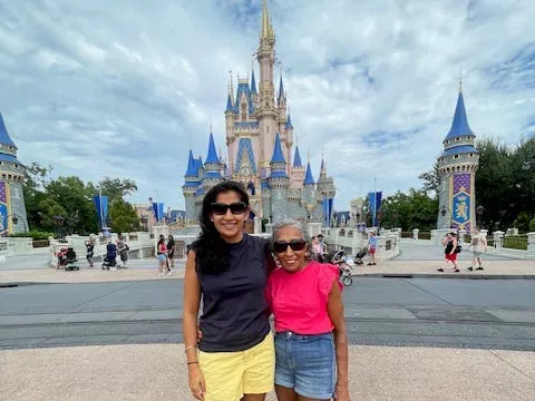 Una mujer abraza a su madre mientras están en un parque de atracciones.